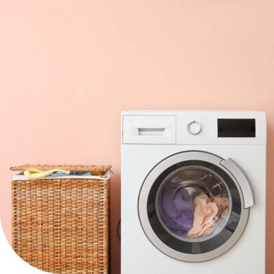 Wasmachine wit en rieten wasmand
